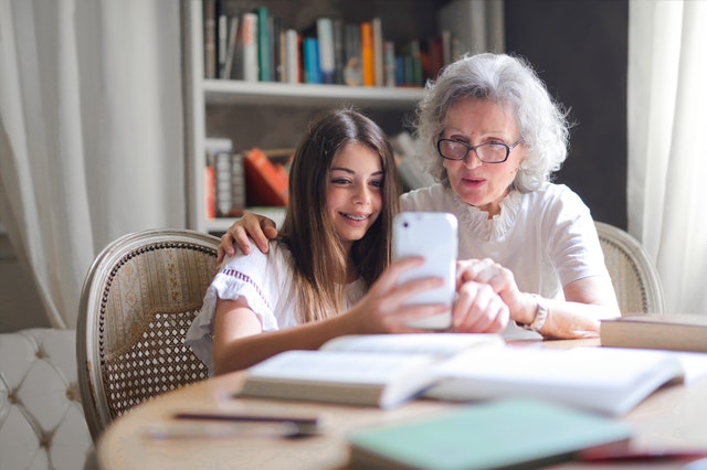 photo of woman showing her cellphone to her grandmother 3768140