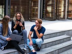 three persons sitting on the stairs talking with each other 1438072