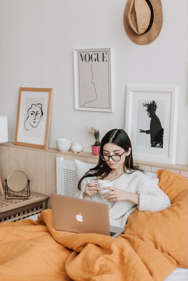 woman having coffee and using laptop in bed 4050389