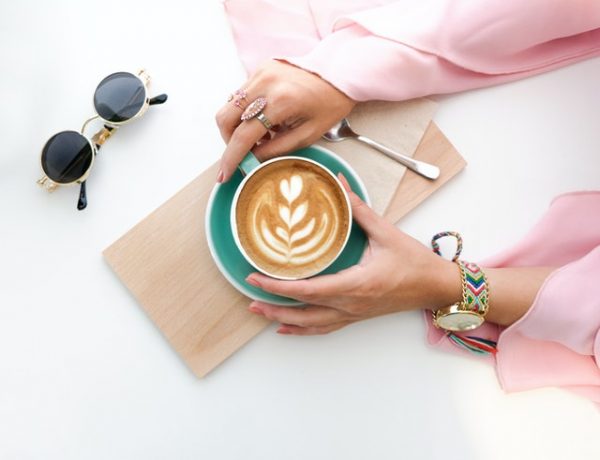 woman holding cup of latte 1260591