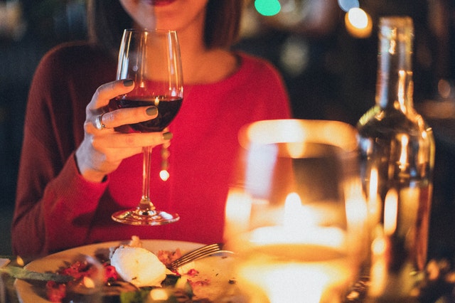 woman holding wine glass selective focus photography 1850595