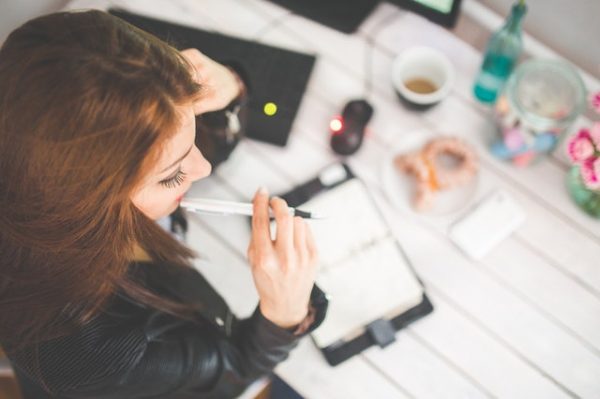 young woman thinking with pen while working studying at her 6384